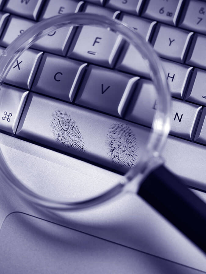 förstoringsglas och fingeravtryck på tangentbord